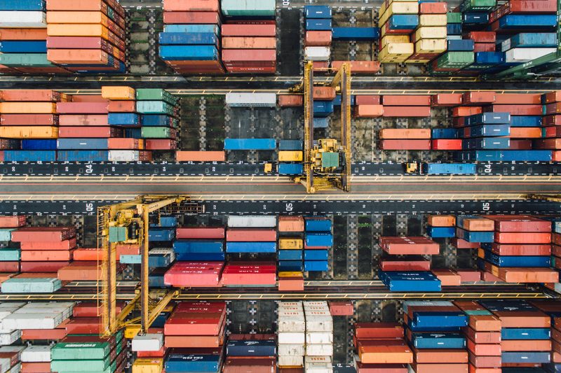 Shipping containers seen directly from above, stacked in colour-coded rows.