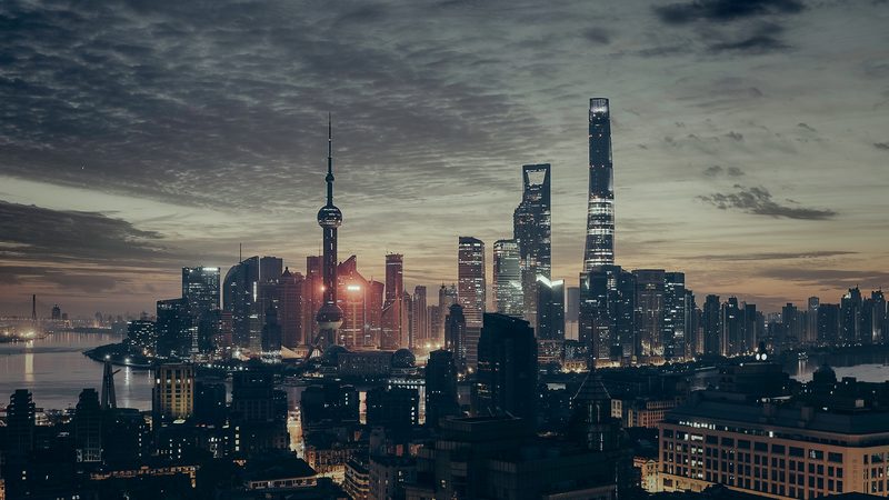 A dense city skyline under a dramatic evening sky.